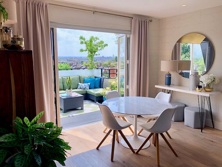 A blue & brass living & dining room with a geometric patterns and a pop ...